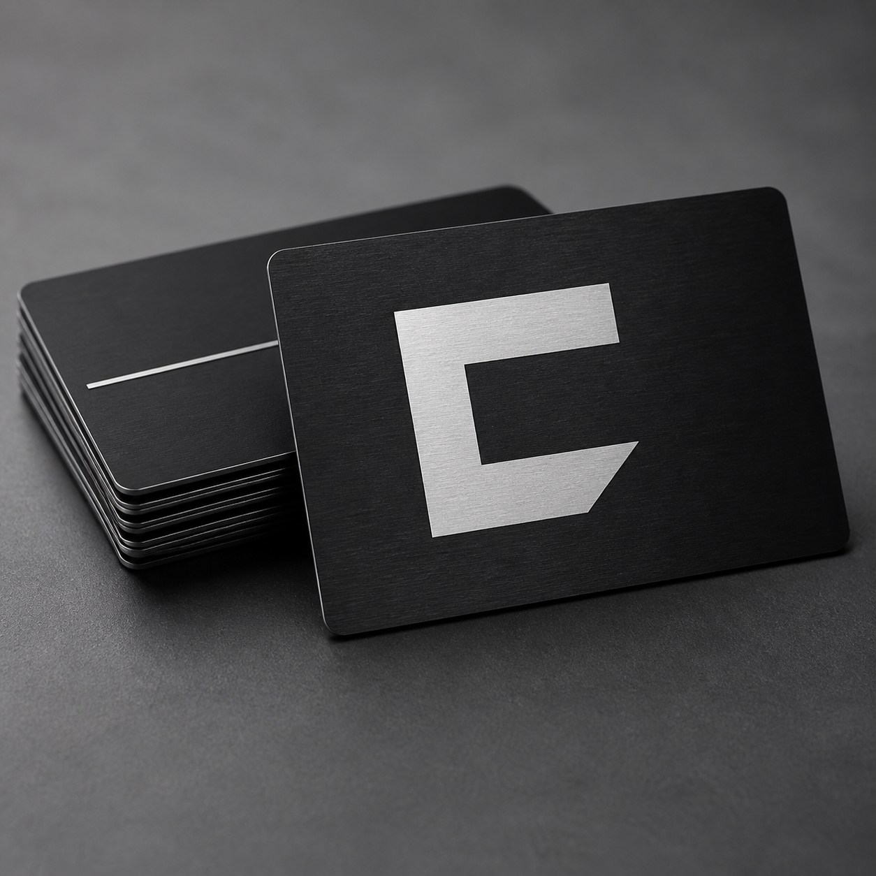 Studio render of black anodized aluminum business cards with silver engraving